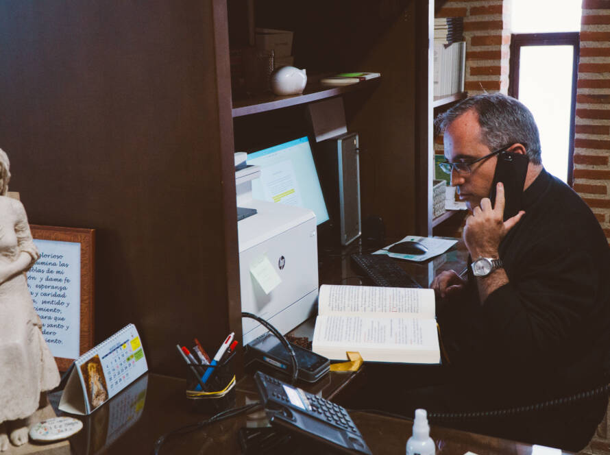 A man talking into the phone while at a desk